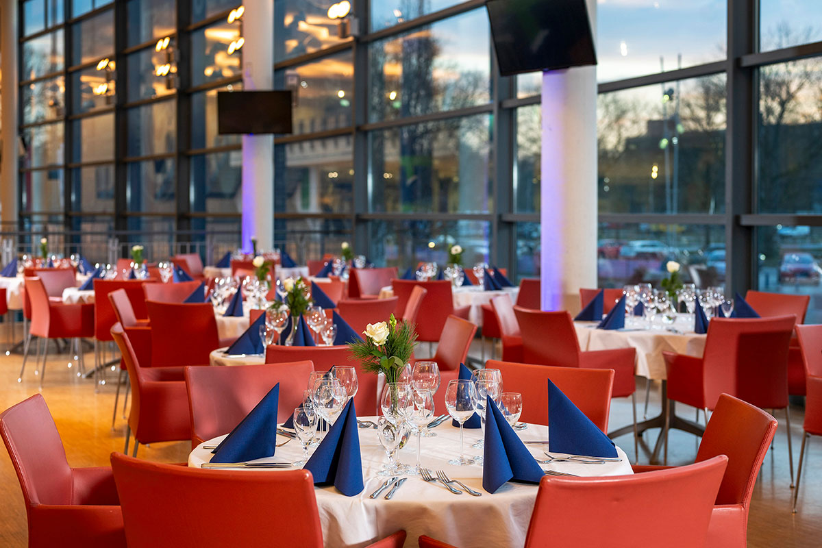 Galerie Nord und Süd mit bodentiefen Fenstern und runden Tischen