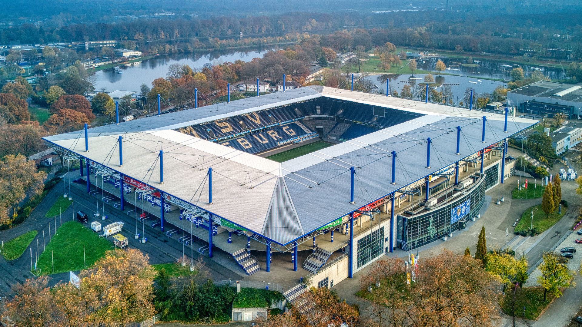 Luftaufnahme der Schauinsland-Reisen-Arena in Duisburg an einem bewölkten Tag, umgeben von viel Grün