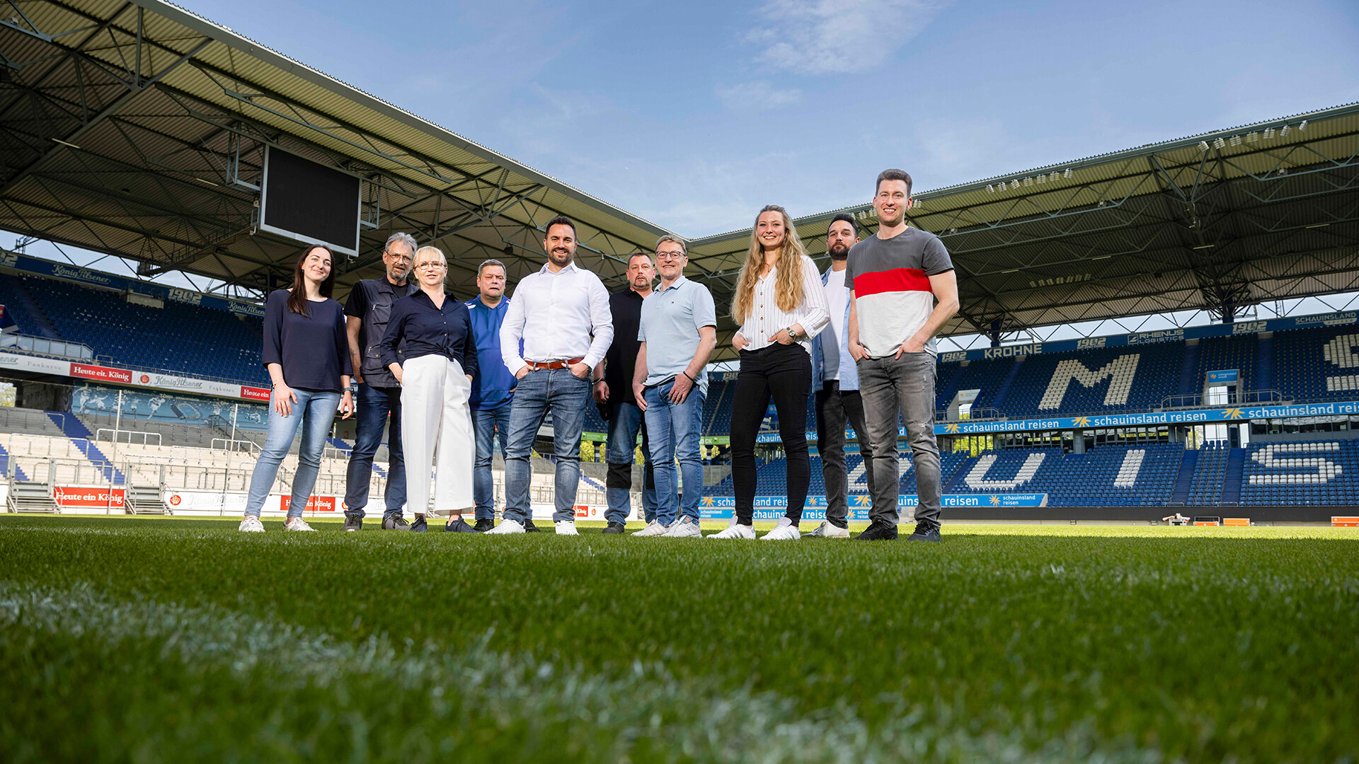 Das Team der Duisburger Stadionmanagement GmbH (DSM) steht gemeinsam auf dem Rasen der Schauinsland- Reisen-Arena