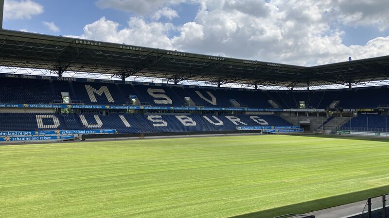Das Bild zeigt das Fußballstadion in Duisburg von innen. Der Fokus liegt auf dem Rasen.
